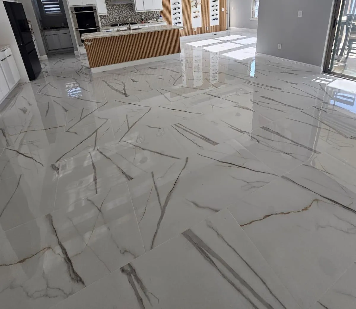 Piso de porcelanato blanco tipo mármol de gran formato, instalado por Yoll Remodeling en una cocina abierta en Orlando