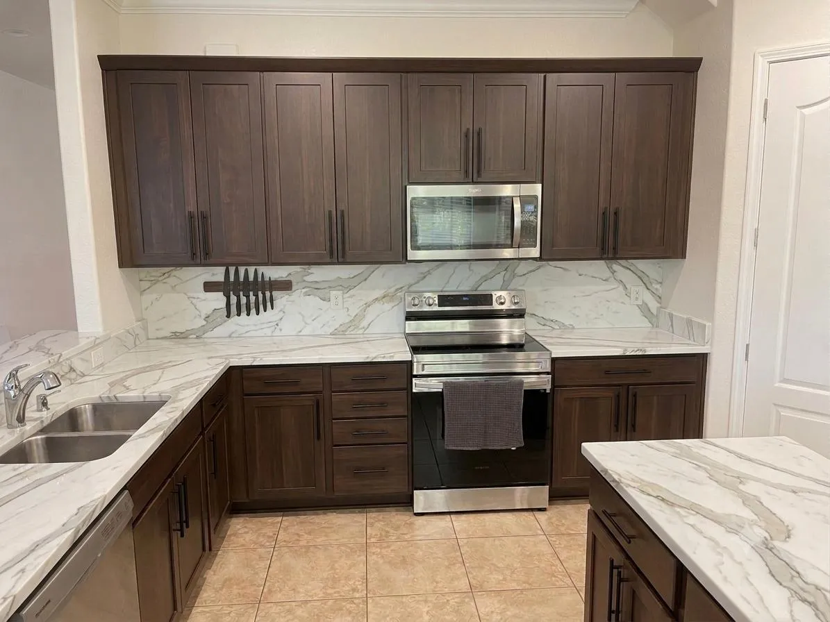 Dark shaker cabinets, Calacatta-style quartz and full backsplash. A Yoll Remodeling job in Orlando and Central Florida