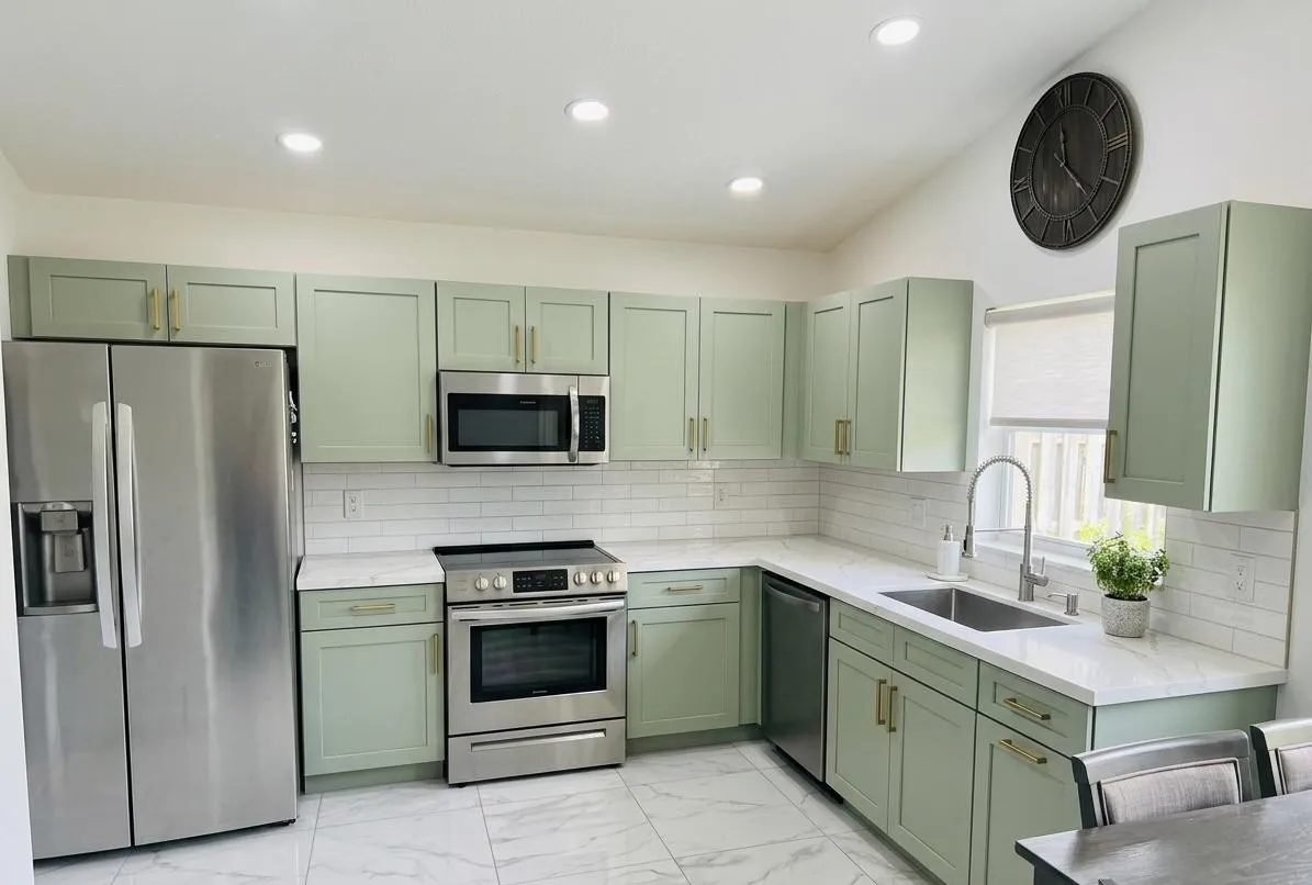 Sage shaker cabinets, brass pulls, white quartz. A Yoll Remodeling job in Orlando and Central Florida