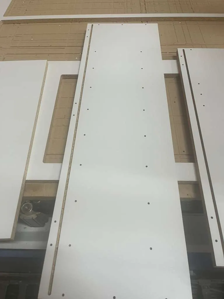 Cut cabinet side panels with drilled shelf holes